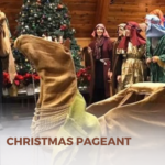 People dressed up as shepherds for a Christmas pageant, with a fake camel.